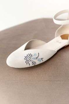 a pair of white shoes with blue flowers on them