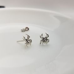 Sterling  Silver Spider Earrings These Halloween themed sterling silver spider stud earrings perfect for adding a hint of Halloween spirit to your look, the frightful yet delightful design features detailed miniature spider crafted with the quality sterling  silver, ensuring that they will last you through many Spookytacular seasons! Size: approximately 8mm x 10mm Finish: platinum plated on top of the sterling silver. Post size: 22 gauge, 11mm long Sold as a PAIR Comes with gift box Earring back Spider Stud Earrings, Spooky Silver Pierced Earrings, Spooky Silver Nickel-free Earrings, Spooky Nickel-free Silver Earrings, Spooky Silver Dangle Earrings, Halloween Sterling Silver Dangle Earrings, Handmade Sterling Silver Halloween Earrings, Spooky Silver Earrings For Gift, Silver Spooky Halloween Earrings