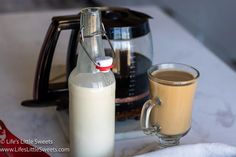 a cup of coffee next to a bottle of milk