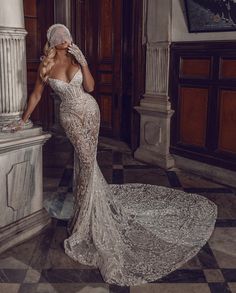 a woman in a wedding dress standing next to a pillar