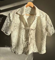 Vintage cream lace collared shirt with front ties. Perfect, one of a kind, style for spring and summer. Can be worn tied together for a night out to dinner, or loosely to the beach. Made from a vintage lace tablecloth. Size works at a range from small to medium. Measurements are: pit-to-pit 20 1/2', length (top of shoulder to hem) 20 1/4 " Vintage Lace Tablecloth, Style For Spring, Lace Tablecloth, Tucson Az, Lace Collar, Cream Lace, Collared Shirt, Vintage Lace, Tucson