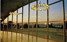 an empty room with large windows and chandelier hanging from it's ceiling