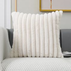 a white pillow sitting on top of a couch