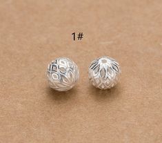 two silver colored beads with numbers on them