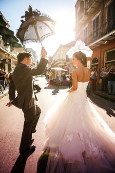 a bride and groom dancing in the street