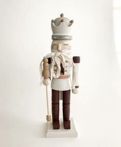 a nutcracker with a hat and cane standing in front of a white background