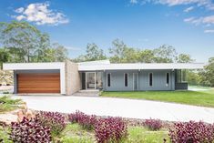 a modern house in the middle of a lush green field