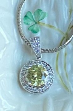 "This is a vintage silver necklace with classic light green round Peridot center rhinestone with small diamond like rhinestones surrounding it.  This is a beautiful piece of jewelry for an upcoming wedding or holiday events. It would accent any colors for causal or dressy style. Bring this necklace to your happy place! Excellent vintage condition. Silver toned necklace length approximately 9\" long. The bright pendant measures 1.25\"x 1.25\". All stones present. Lots of sparkling! Thanks for sto Yellow Round Pendant Jewelry For Wedding, Yellow Round Pendant Wedding Jewelry, Wedding Silver Diamond Necklace With Birthstone, Green Necklace With Halo Setting For Wedding, Dazzling Green Diamond Necklace For Anniversary, Green Halo Setting Necklace For Wedding, Dazzling Round Rhinestone Necklace With Diamond Accents, Silver Diamond Necklace For May Birthstone, May Birthstone Necklaces With Diamond Accents