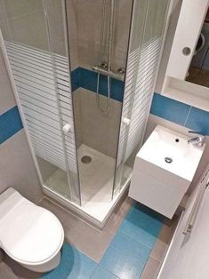 a bathroom with a toilet, sink and stand up shower stall in it's corner