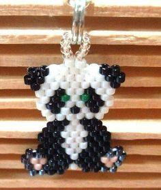 a beaded panda bear is hanging from a chain