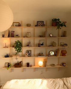 a bed with a white comforter and shelves on the wall