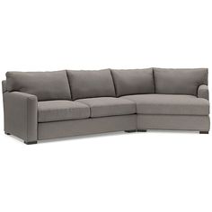 a gray sectional couch sitting on top of a white floor