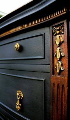 a black dresser with gold handles and knobs