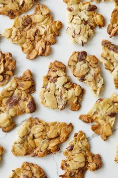 an assortment of cookies and granola on a white surface with one broken in half