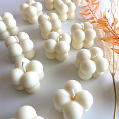 white beads are arranged on a table next to a flower and some other things in the background