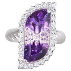 This ring is truly magnificent! The center stone is a unique and gorgeous 5.58 carat bi-color amethyst that was cut by an award winning gemstone cutter here in Arizona. Accenting this one of a kind stone is .44 carats of beautiful diamonds. All set in 14k white gold. Ring size is a 7. Additional sizes available upon request. Award Winning Jewelry, Twist Ring, Cocktail Rings, Arizona, Twist, Ring Size, Amethyst, Jewelry Rings, White Gold