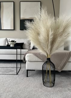 a white couch sitting next to a black birdcage on top of a floor