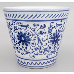 a blue and white flower pot with designs on the outside, sitting in front of a gray background