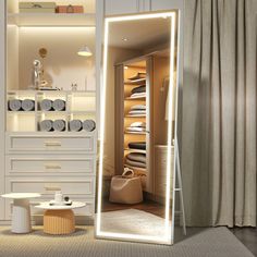 an illuminated mirror in the corner of a room next to a white dresser and chair