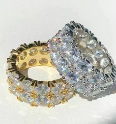 two gold and silver rings with crystal stones on each ring, one in the middle