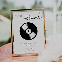 a sign that says for the record please sign our guest book on top of a wooden table