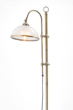 an antique style floor lamp with a glass shade on the top and bottom, against a white background