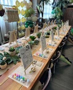 a long table is set up with place cards and succulents