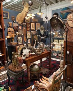 a room filled with lots of assorted items and decor on display in front of a wooden desk