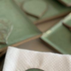 a table topped with green plates and napkins