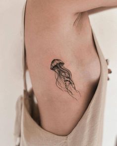 a woman's stomach with a tattoo of a jellyfish on her left side