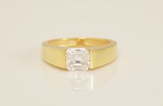 a yellow gold ring with an oval cut diamond in the center, on a white background