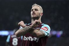 a man with tattoos standing in front of a black background and the words west ham on it