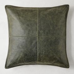 a green leather pillow on a white wall