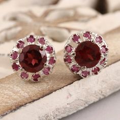 Harmonious pink and red gems come together on Bhavya Jain small but stunning stud earrings. The artisan crafts the earrings from rhodium-plated sterling silver, centering the pair with a single faceted garnet stone. A ring of deep pink rubies circle the garnet with sparkling beauty. Silver Ruby Jewelry With Prong Setting, Silver Garnet Jewelry With Prong Setting, Lab-created Ruby Jewelry Gift With Round Stone, Anniversary Sterling Silver Cluster Earrings, Gift Lab-created Round Ruby Jewelry, Red Sterling Silver Jewelry With Round Stone, Ruby Gemstone Earrings As Gift, Silver Jewelry With Round Lab-created Ruby, Nickel-free Red Jewelry For Anniversary