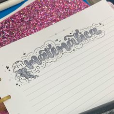 a notepad with writing on it next to a pen and some glittery paper