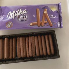 a box of milk filled chocolates next to a package of milk covered hot dogs