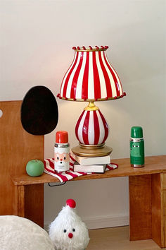 a lamp that is sitting on top of a wooden table next to a stuffed animal