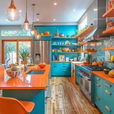 an orange and blue kitchen with lots of counter space in the center, along with wooden flooring