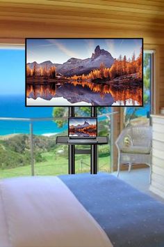 a bedroom with a bed, television and balcony overlooking the ocean is shown in this image