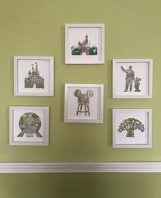 four framed pictures hang on the wall above a bed in a room with green walls