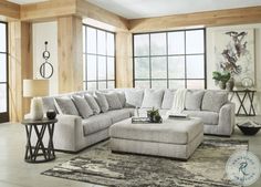 a living room with large windows and a sectional couch in the middle of the room