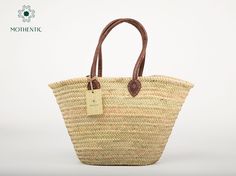 Handmade in Morocco, the basket features 2 Brown Long leather straps to be held in hands. It can be used as a chic shopping bag a unique tote, going to the beach, or a picnic. It's great for storing toys, umbrellas, books towels, magazines, and lots of other things. All our bags are Handwoven by women in Morocco using palm leaf and crafted in our workshop, they are both sturdy, flexible and they're eco-friendly. Approx size :  +Length: 54cm / 21in    +Height: 35cm / 13,7in  +Handle: 70cm / 27,5i Storing Toys, Natural Baskets, Going To The Beach, Palm Leaf, Toy Store, Long Handles, Plastic Bag, Purses And Handbags, Morocco