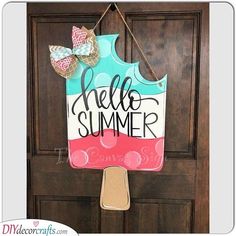 a door hanger that says hello summer with a bow hanging from it's side