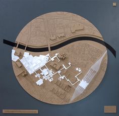 a circular cut out of wood with buildings and streets in the center, on top of a blue wall