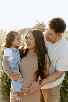 a man, woman and child are smiling at each other