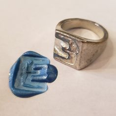 a silver ring with a blue plastic object next to it