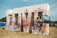 two people are climbing up the letters made out of paper machs and spray paint