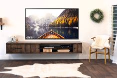 a large flat screen tv mounted to the side of a wooden entertainment center in a living room