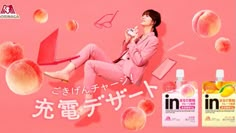 a woman sitting on top of a pink surface next to peaches and other items