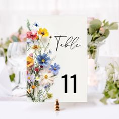 there is a table number with flowers on it